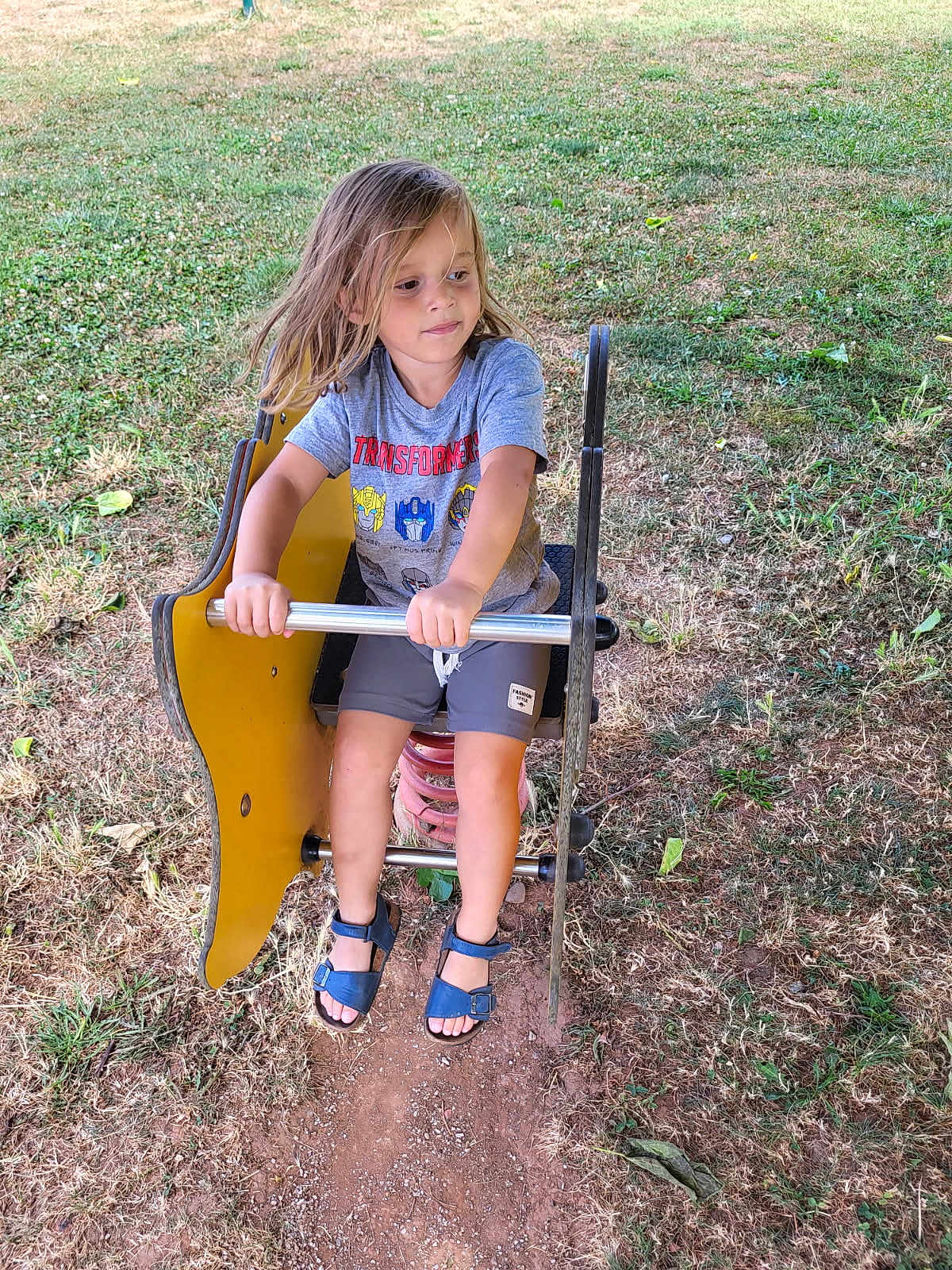 Lyham a rejoint le concours — aidez-le/la à gagner de superbes lots ! child, playground, spring_rider, yellow, grass, outdoor, summer, casual_clothing, shorts, sandals, metal_bar, toy, recreation, nature, person, young, play, fun, park, daylight