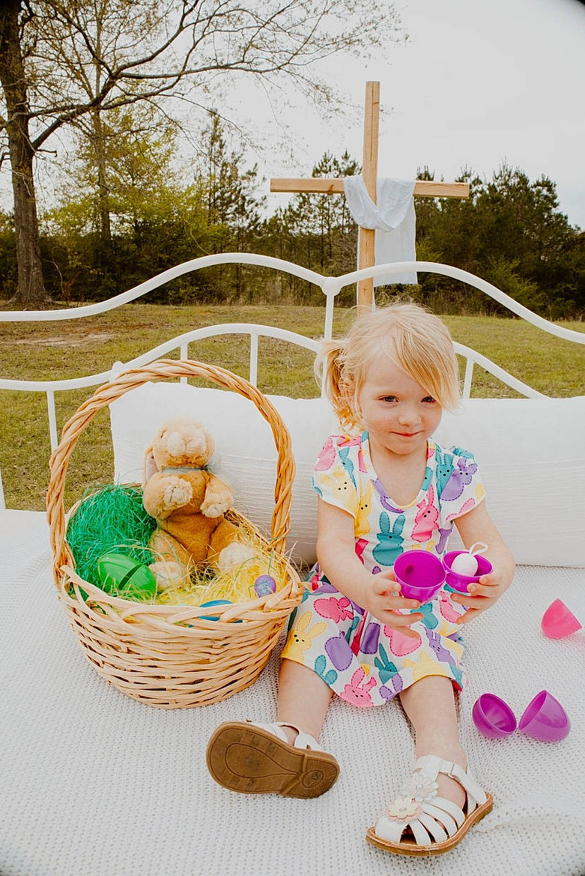Adaleigh is registered to the contest to win money with this photo: baby_toddler_clothing, basket, child, event, fun, grass, happy, joy, leisure, mammal, pattern, person, picnic_basket, plant, recreation, smile, storage_basket, toddler, toy, tree