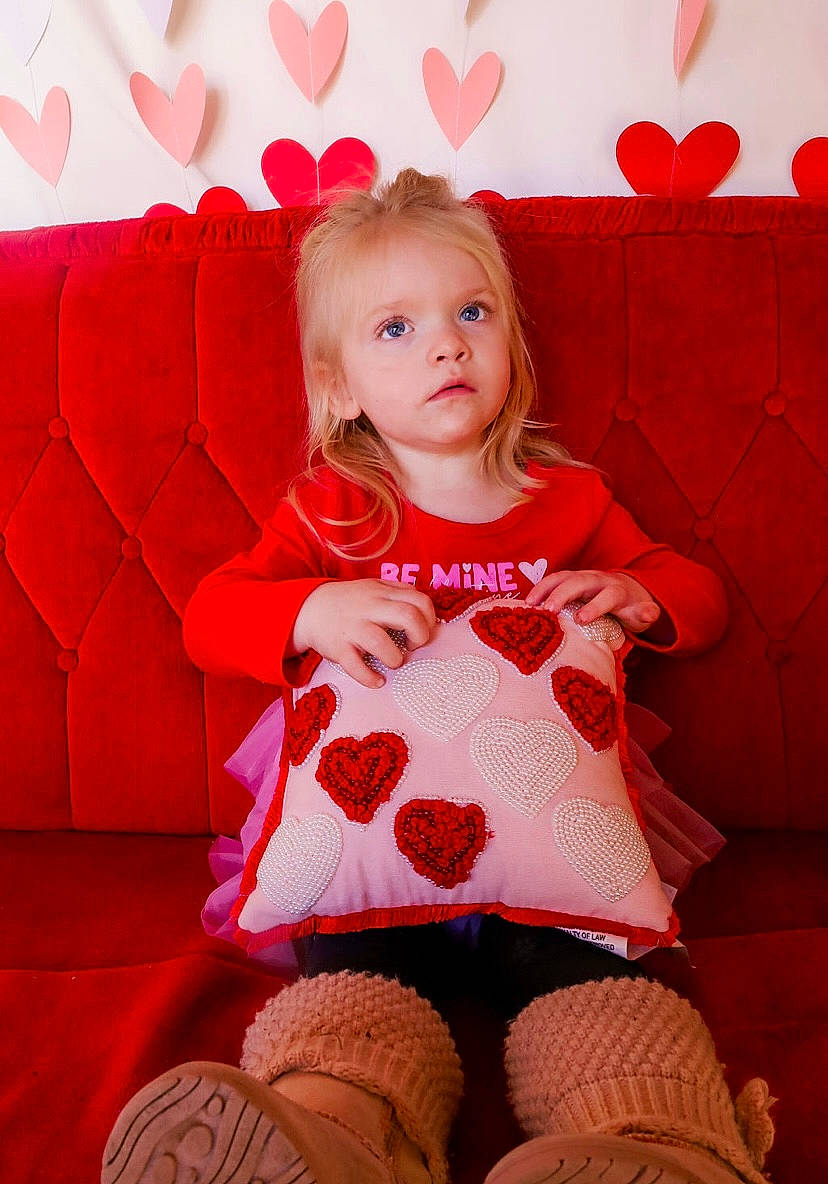 Adaleigh is registered to the contest to win money with this photo: baby_toddler_clothing, beauty, blond, comfort, face, happy, human_leg, knee, lap, magenta, mammal, pattern, person, pink, red, sitting, skin, sleeve, sock, thigh