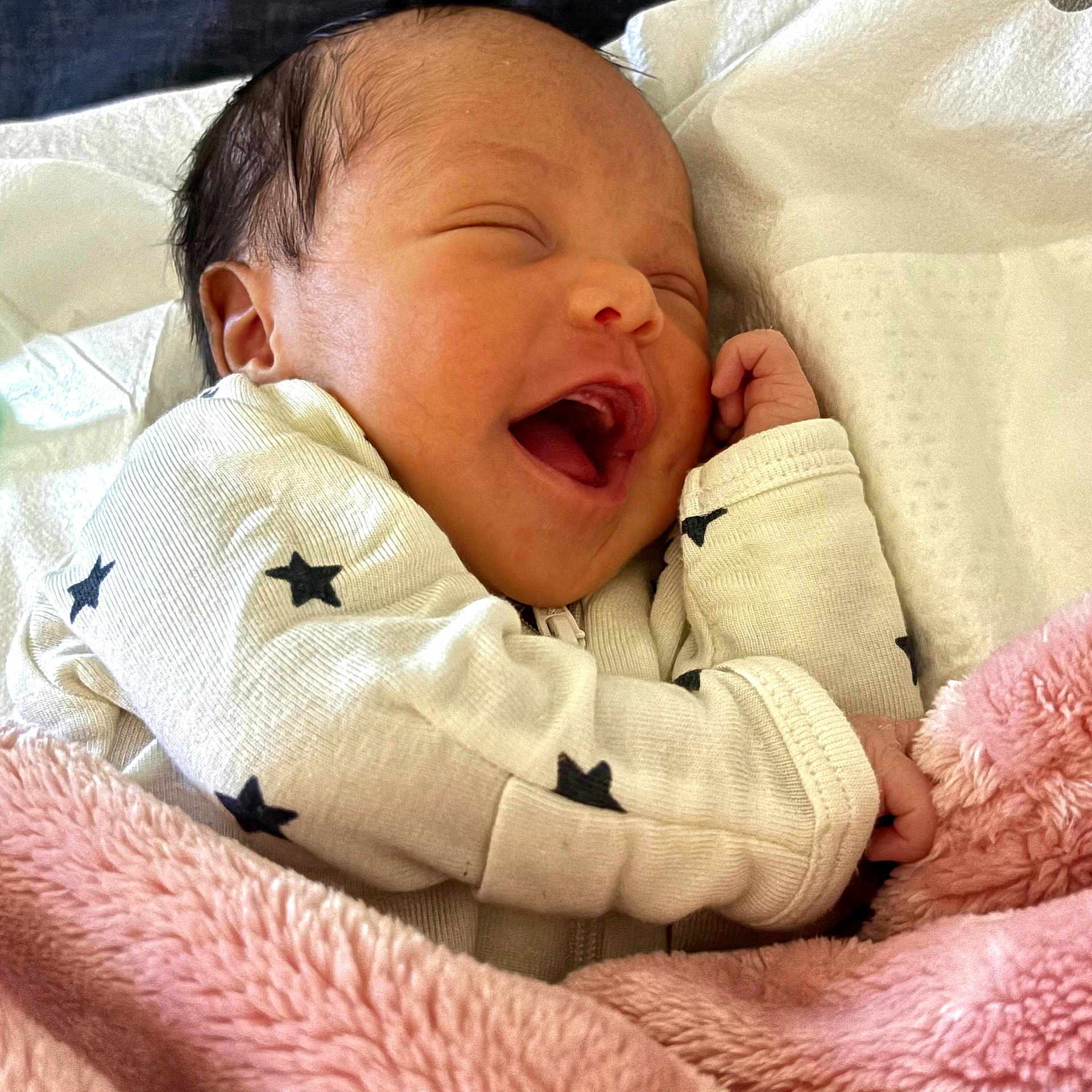 Mu'Lani joined the competition — help win amazing prizes! baby, newborn, infant, smiling, laughing, blanket, pink_blanket, star_pattern, clothing, cute, sleepwear, face, happy, small_hands, soft_texture, cozy, resting, indoors, child, portrait