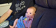 Xalia is registered to the contest to win money with this photo: baby, man, indoor, couch, blanket, clothing, pacifier, baby_accessory, person, portrait, relaxing, looking_down, cute, family, child, seated, furniture, casual, home, toddler