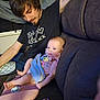 baby, man, indoor, couch, blanket, clothing, pacifier, baby_accessory, person, portrait, relaxing, looking_down, cute, family, child, seated, furniture, casual, home, toddler