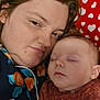 Xalia is registered to the contest to win money with this photo: woman, baby, sleeping, close_up, face, pillow, heart_pattern, indoor, cozy, skin, expression, head, person, child, red, brown_clothing, floral_pattern, resting, mother, infant