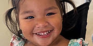 Keyianah Star is registered to the contest to win money with this photo: child, toddler, smiling, dress, pigtails, stroller, indoor, happy, cute, face, hair, person, young_child, seated, colorful_clothing, flower_pattern, toothysmile, portrait, bright_lighting, background_blur
