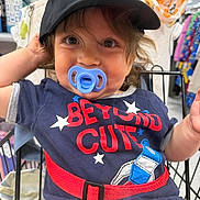 Rockland joined the competition — help win amazing prizes! toddler, child, pacifier, cap, black_cap, shopping_cart, blue_shirt, red_text, clothing, cute, smiling, indoor, store, aisle, person, baby, face, curly_hair, playful, casual