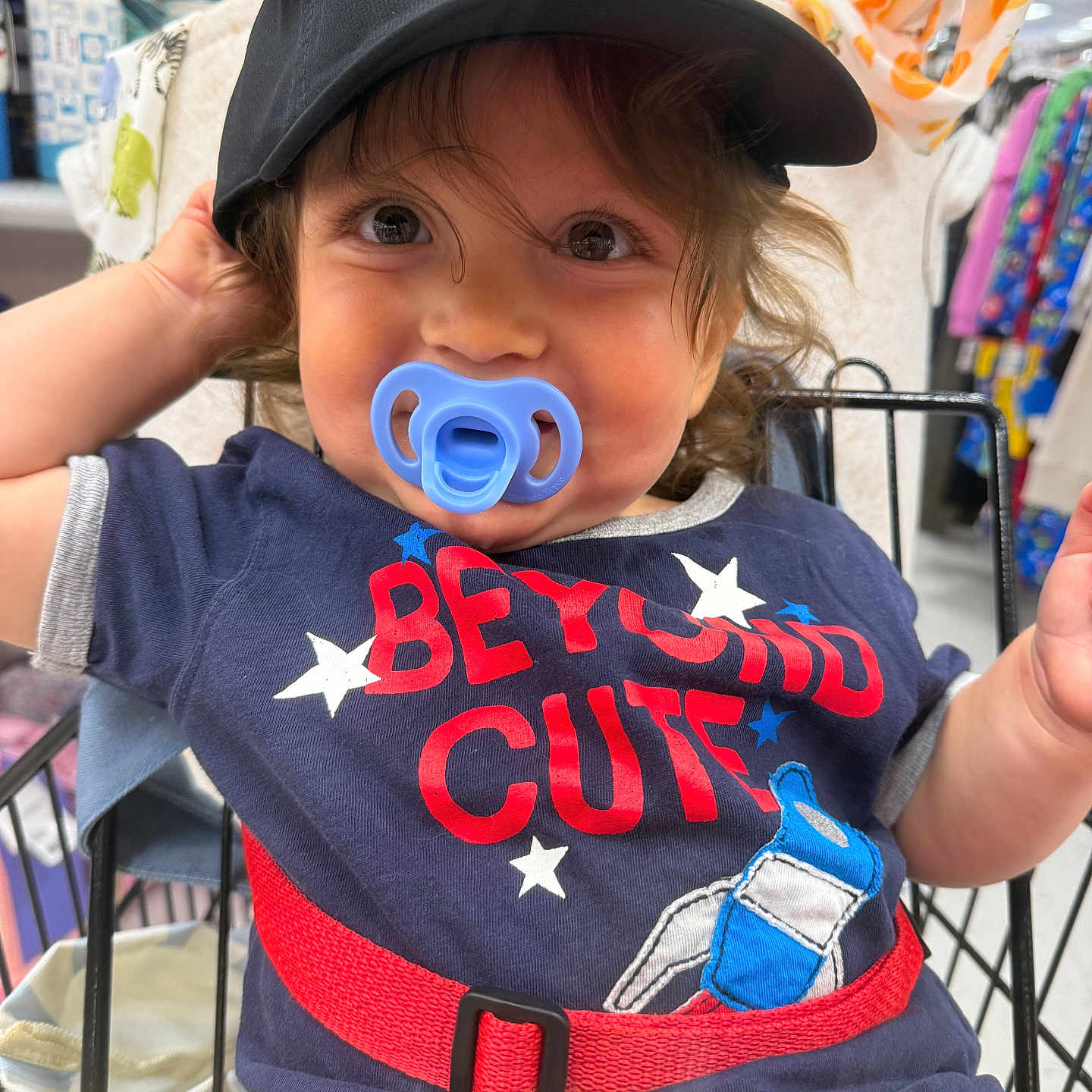 Rockland joined the competition — help win amazing prizes! toddler, child, pacifier, cap, black_cap, shopping_cart, blue_shirt, red_text, clothing, cute, smiling, indoor, store, aisle, person, baby, face, curly_hair, playful, casual