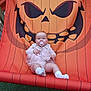 baby, pacifier, chair, orange, pumpkin, halloween, face, wooden_frame, outdoor, grass, baby_clothing, white_socks, infant, toy, cute, smiling, decor, child, funny, portrait