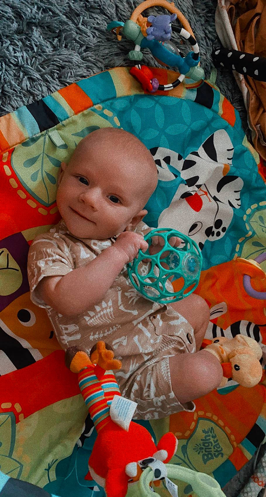 Jasper is registered to the contest to win money with this photo: baby, baby_products, baby_toddler_clothing, cheek, child, doll, fun, head, linens, orange, pattern, person, pink, product, room, smile, stuffed_toy, textile, toddler, toy