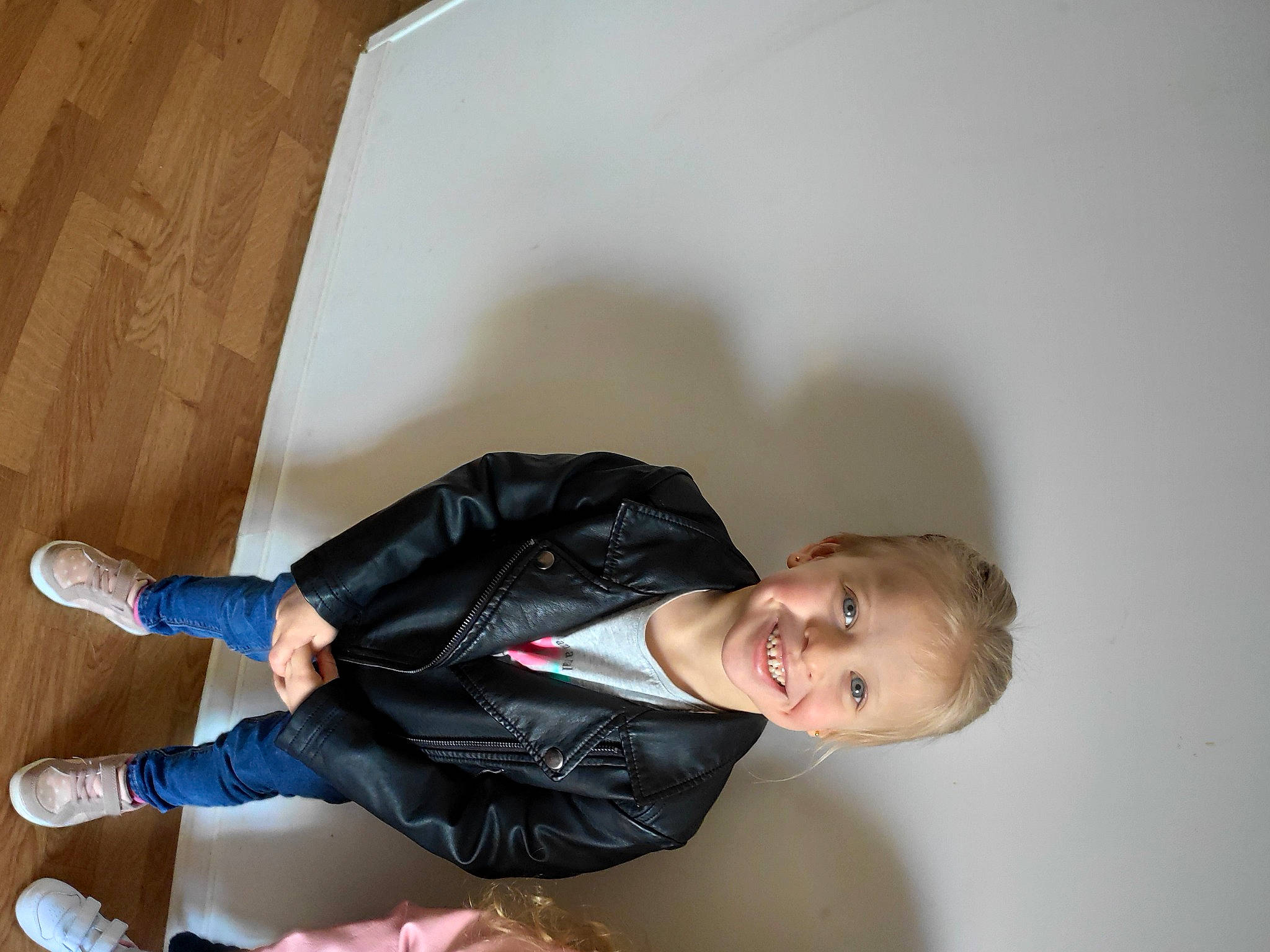 Leyana participe au concours pour gagner de l'argent avec cette photo : child, comfort, flash_photography, flooring, formal_wear, fun, happy, hardwood, human_leg, jacket, joy, knee, leather, leg, person, room, sitting, sleeve, smile, sock