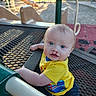 Horace is registered to the contest to win money with this photo: baby, blue_eyes, casual_wear, child, clothing, cute, daylight, fun, infant, metal_table, outdoor, park, person, play_equipment, playground, sitting, slide, smiling, yellow_shirt, young_child