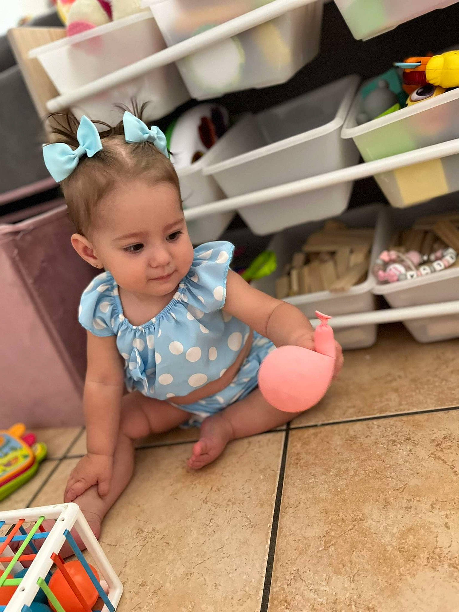 Kélya a rejoint le concours — aidez-le/la à gagner de superbes lots ! baby, baby_toddler_clothing, child, design, fashion_accessory, flooring, fun, happy, hardwood, headband, person, pink, play, product, room, shelf, sitting, skin, smile, toddler