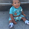 Kaida is registered to the contest to win money with this photo: baby, child, smiling, sitting, curly_hair, blue_shirt, checkered_shorts, socks, pacifier_clip, outdoor, vehicle, concrete, happy, cute, infant, young_child, playful, casual_clothing, daylight, portrait