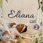 Eliana joined the competition — help win amazing prizes! advertisement, baby, blanket, clothing, crib, face, flower, furniture, hat, head, infantbed, newborn, person, photography, plant, portrait, rose, sleeping, sleeve, text
