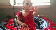 Ashley joined the competition — help win amazing prizes! accessories, bright_light, casual, child, colorful, cute, fashion, fun, handbags, heart_shaped_sunglasses, indoor, playful, portrait, posing, red_dress, room, smile, toy_car, window, young_girl