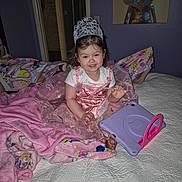 Ashley joined the competition — help win amazing prizes! child, toddler, princess_dress, tiara, crown, tablet, tablet_case, blanket, pink_blanket, bed, quilt, smile, bedroom, painting, frog_painting, purple_wall, feet, barefoot, nightgown, portrait