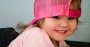 Ashley is registered to the contest to win money with this photo: backward_hat, baseball_cap, child, close_up, clothing, couch, eyes, face, girl, hair, happy, home, indoors, pink_hat, pink_shirt, portrait, seated, smiling, toddler, wall