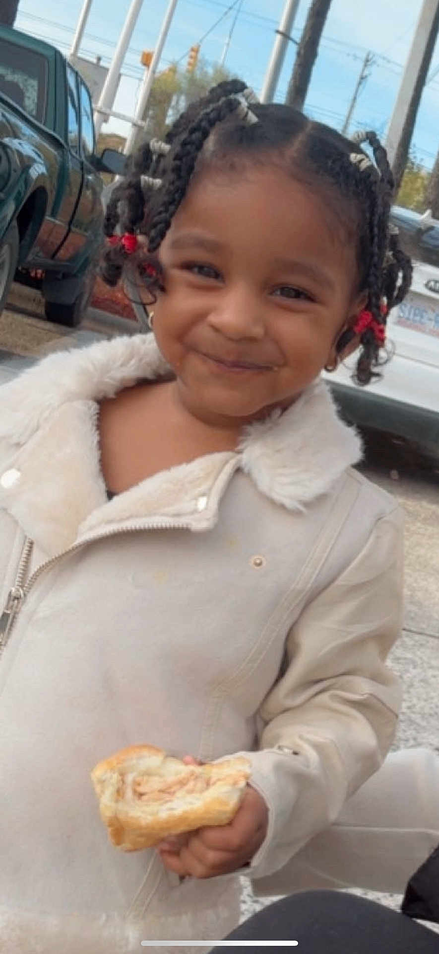 Retaan joined the competition — help win amazing prizes! child, smiling, braided_hair, jacket, sandwich, street, outdoor, person, vehicle, car, happy, food, holding, curly_hair, casual_clothing, daytime, cute, portrait, young_child, urban