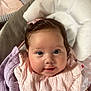 Lottie joined the competition — help win amazing prizes! baby, infant, smiling, face, blanket, cushion, pink_clothing, bow, indoor, cute, child, portrait, soft_texture, happy, closeup, head, skin, comfort, young, adorable