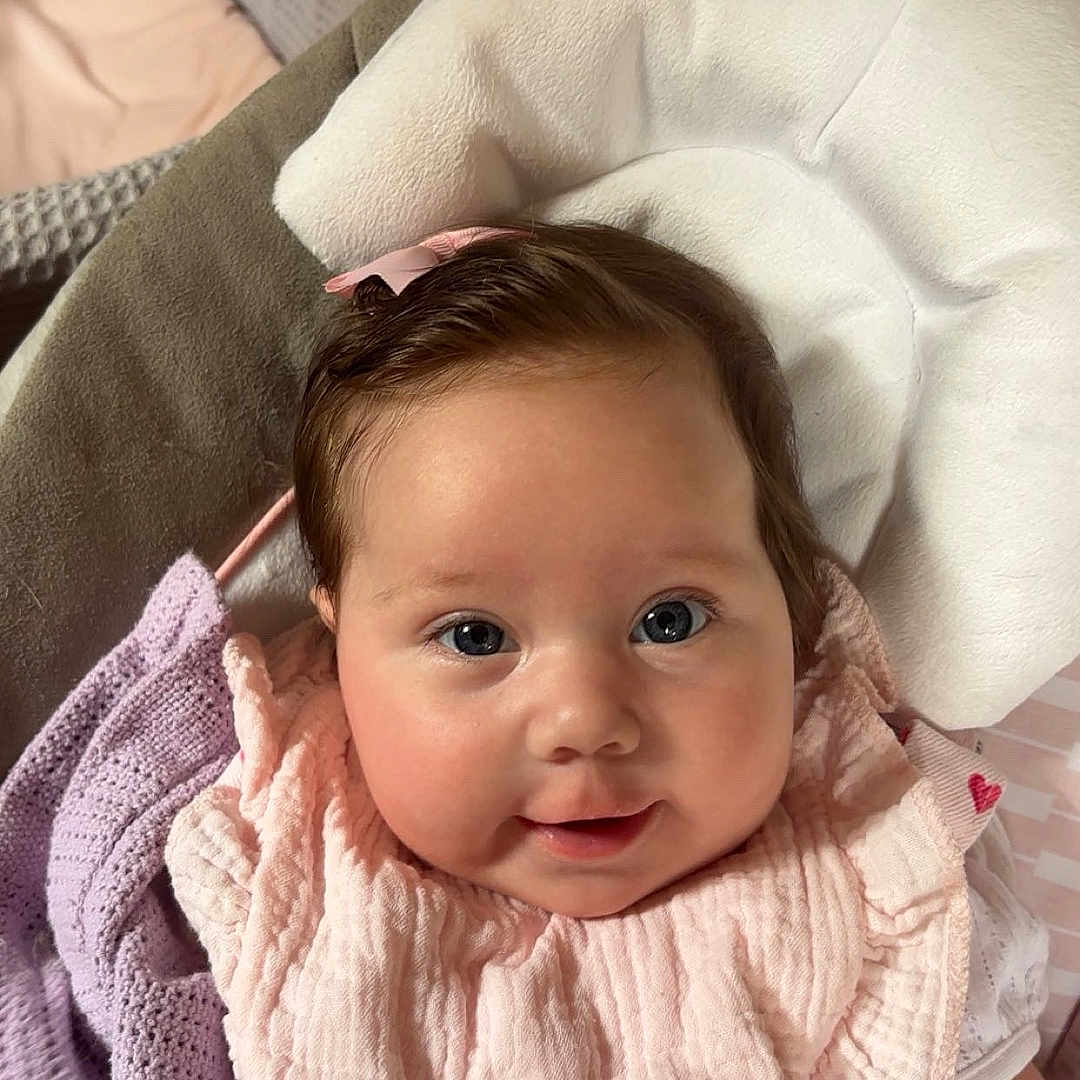 Lottie joined the competition — help win amazing prizes! adorable, baby, blanket, bow, child, closeup, comfort, cushion, cute, face, happy, head, indoor, infant, pink_clothing, portrait, skin, smiling, soft_texture, young