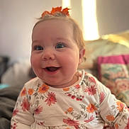 Lottie joined the competition — help win amazing prizes! baby, child, smiling, happy, face, flower_pattern, floral_clothing, indoor, portrait, cute, infant, childhood, warm_light, soft_focus, person, head, hair_accessory, orange_leaf, sitting, cozy