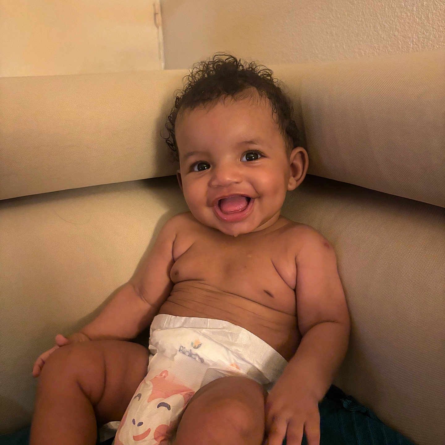 Vanessa participe au concours pour gagner de l'argent avec cette photo : baby, child, comfort, couch, curly_hair, cute, diaper, dimples, furniture, happy, indoor, infant, person, portrait, relaxing, seated, skin, smiling, toddler, young