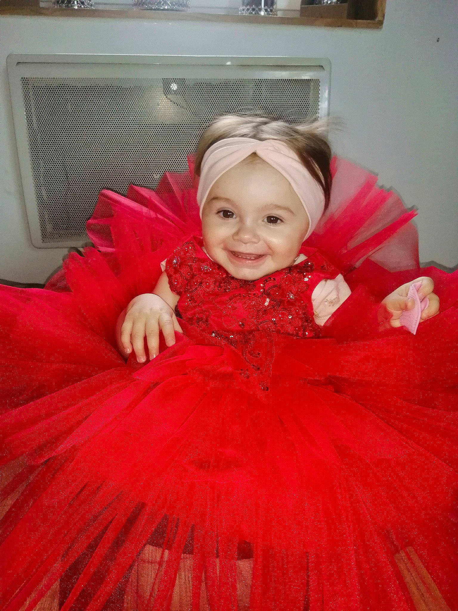 Mia a rejoint le concours — aidez-le/la à gagner de superbes lots ! baby_toddler_clothing, bridal_accessory, couch, dress, embellishment, event, flash_photography, happy, headpiece, headwear, joy, magenta, organ, outerwear, person, picture_frame, pink, sleeve, smile, standing