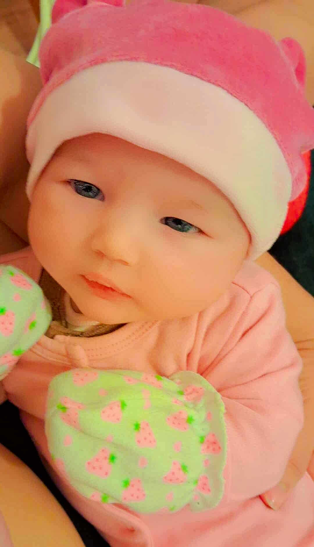 Crystal Enouf participe au concours pour gagner de l'argent avec cette photo : baby, infant, pink_hat, pink_mittens, strawberry_pattern, close_up, soft_focus, infant_clothing, cute, child, newborn, face, skin, portrait, young_child, sleepy, cozy, baby_outfit, hands, headwear