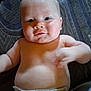 Randy is registered to the contest to win money with this photo: baby, infant, diaper, skin, face, cheeks, arm, hand, lying_down, patterned_background, soft_light, curious_expression, indoors, child, cute, plump, young, portrait, closeup, person