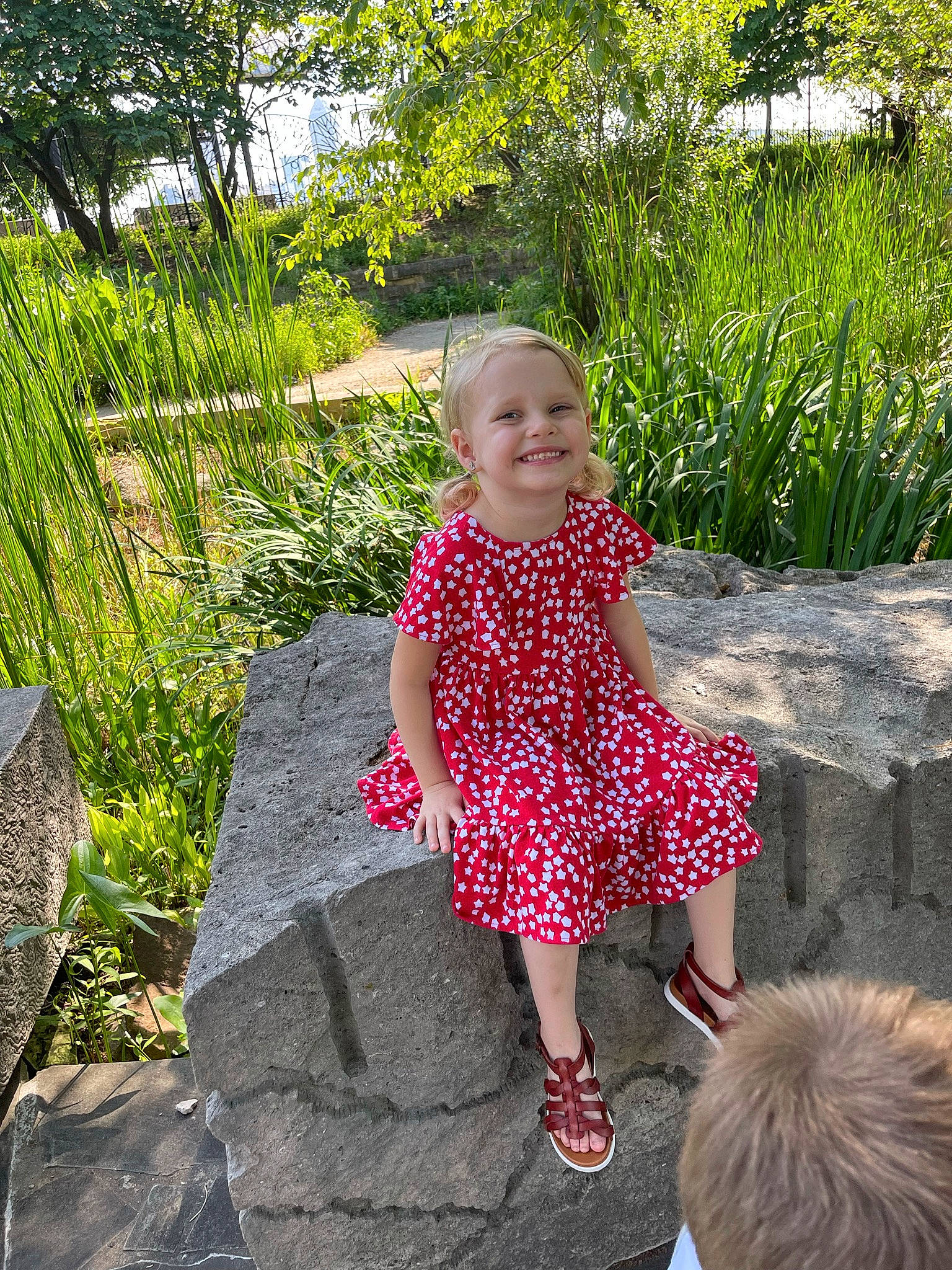 Allyson is registered to the contest to win money with this photo: baby_toddler_clothing, beauty, child, day_dress, dress, fun, garden, grass, grass_family, happy, joy, leisure, magenta, pattern, people_in_nature, person, plant, sitting, smile, terrestrial_plant