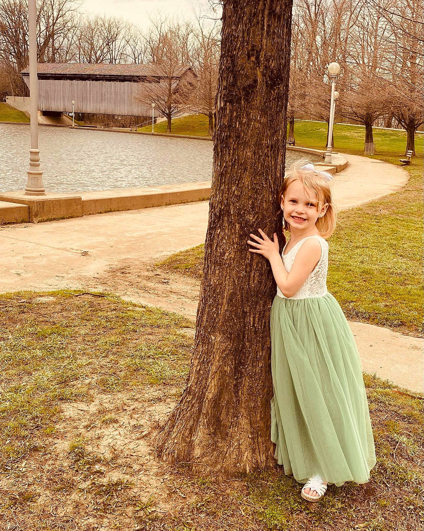 Allyson is registered to the contest to win money with this photo: botany, branch, eye, gesture, grass, happy, joy, leisure, nature, people_in_nature, person, plant, recreation, smile, sunlight, tints_and_shades, tree, trunk, waist, wood