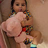 baby, child, infant, portrait, lying_down, pacifier, plush_toy, stuffed_animal, pink_bunny, purple_toy, bed, crib, bedding, pillow, colorful_clothing, onesie, socks, blue_shoes, diaper, indoor