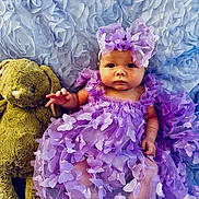 Danica is registered to the contest to win money with this photo: baby, bonnet, cap, clothing, costume, dress, face, flower, flowerarrangement, hat, head, newborn, person, petal, photography, plant, portrait, purple, teddybear, toy