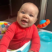 Aiyana joined the competition — help win amazing prizes! baby, bright, child, clothing, colorful, cute, expression, face, furniture, hand, happy, indoors, infant, kitchen, person, play, seat, smiling, toy, walker