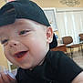 Ryder joined the competition — help win amazing prizes! baby, child, smiling, black_cap, black_shirt, indoor, face, happy, young_child, person, candid, cute, expression, headwear, seated, furniture, blurred_background, room, joyful, portrait