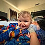 Eros is registered to the contest to win money with this photo: baby, child, blanket, smile, indoor, toy, face, person, bed, furniture, television, fan, curtains, clothing, home, room, colorful, crawling, happy, infant