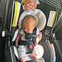 Weston is registered to the contest to win money with this photo: newborn, baby, car_seat, infant, sleeping, harness, toy, barn, clothing, foot, hand, safety, seat, cushion, black, grey, sunlight, shadow, indoor, closeup
