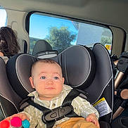 Kayden joined the competition — help win amazing prizes! baby, buckle, car_interior, car_seat, cheeks, clothing, eyes, face, hand, headrest, infant, person, portrait, safety_label, seat_belt, sunlight, toy, tree_outside, upholstery, window