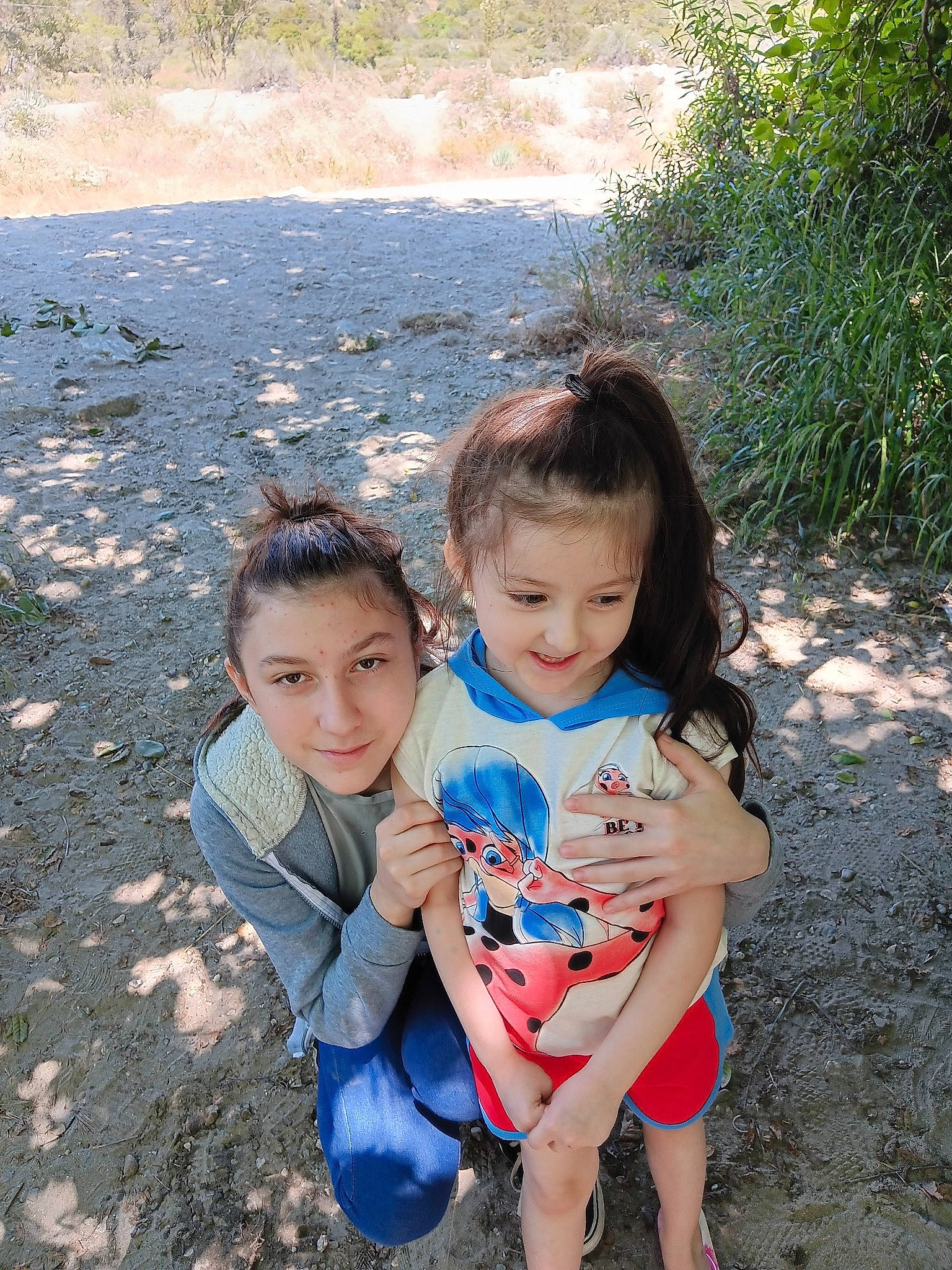 Alana Valdez is registered to the contest to win money with this photo: child, eye, friendship, fun, grass, hand, happy, joy, landscape, leisure, mouth, people_in_nature, person, plant, recreation, sand, sitting, skin, soil, summer