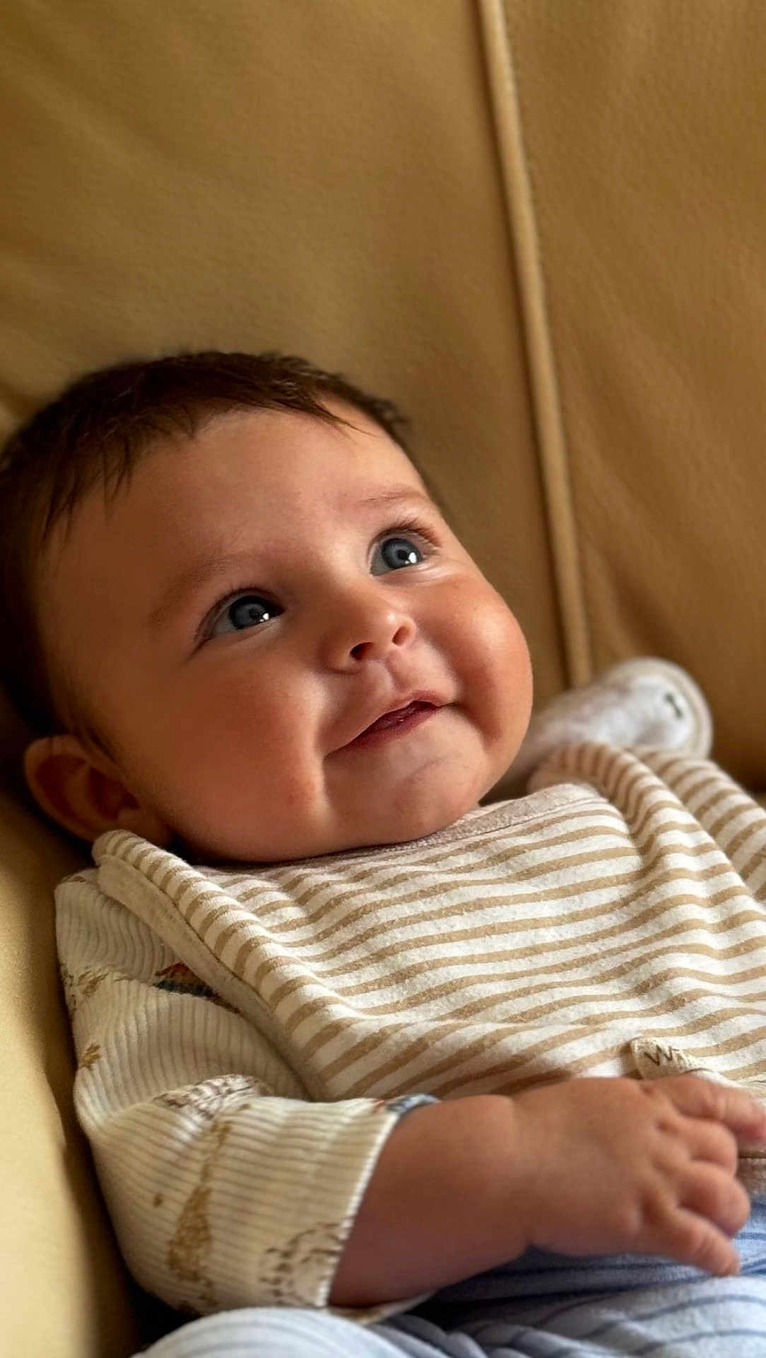 Thomas is registered to the contest to win money with this photo: baby, child, face, smile, blue_eyes, striped_clothing, cheeks, arm, hand, infant, portrait, cute, skin, hair, sitting, cozy, indoor, closeup, happy, soft_light