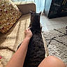 cat, tabby_cat, couch, arm, hand, pillow, curtains, sunlight, shadow, rug, floor_tile, cabinet, indoor, living_room, texture, pattern, resting, pet, cozy, relaxation