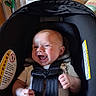 baby, infant, child, car_seat, harness, smiling, laughing, portrait, face, hands, indoor, nursery, clothing, blanket, safety_label, seated, happy, photography, close_up, family