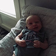 Jade a rejoint le concours — aidez-le/la à gagner de superbes lots ! baby, infant, smile, pillow, onesie, zebra_print, hand, lying_down, bedroom, window, natural_light, soft_light, indoor, child, cute, newborn, person, fabric, relaxing, sleepwear