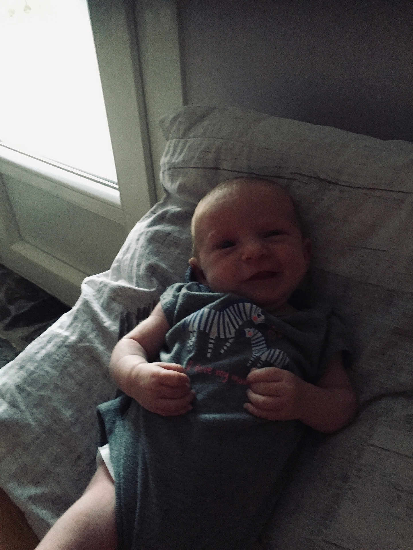 Jade a rejoint le concours — aidez-le/la à gagner de superbes lots ! baby, infant, smile, pillow, onesie, zebra_print, hand, lying_down, bedroom, window, natural_light, soft_light, indoor, child, cute, newborn, person, fabric, relaxing, sleepwear