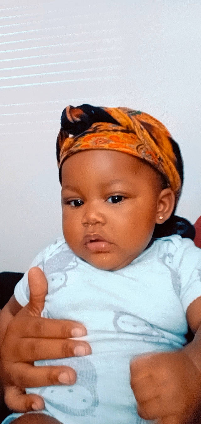 Kennedy is registered to the contest to win money with this photo: baby, baby_toddler_clothing, cheek, dress, eye, eyebrow, eyelash, face, finger, flash_photography, forehead, gesture, happy, headpiece, lip, neck, nose, person, skin, sleeve