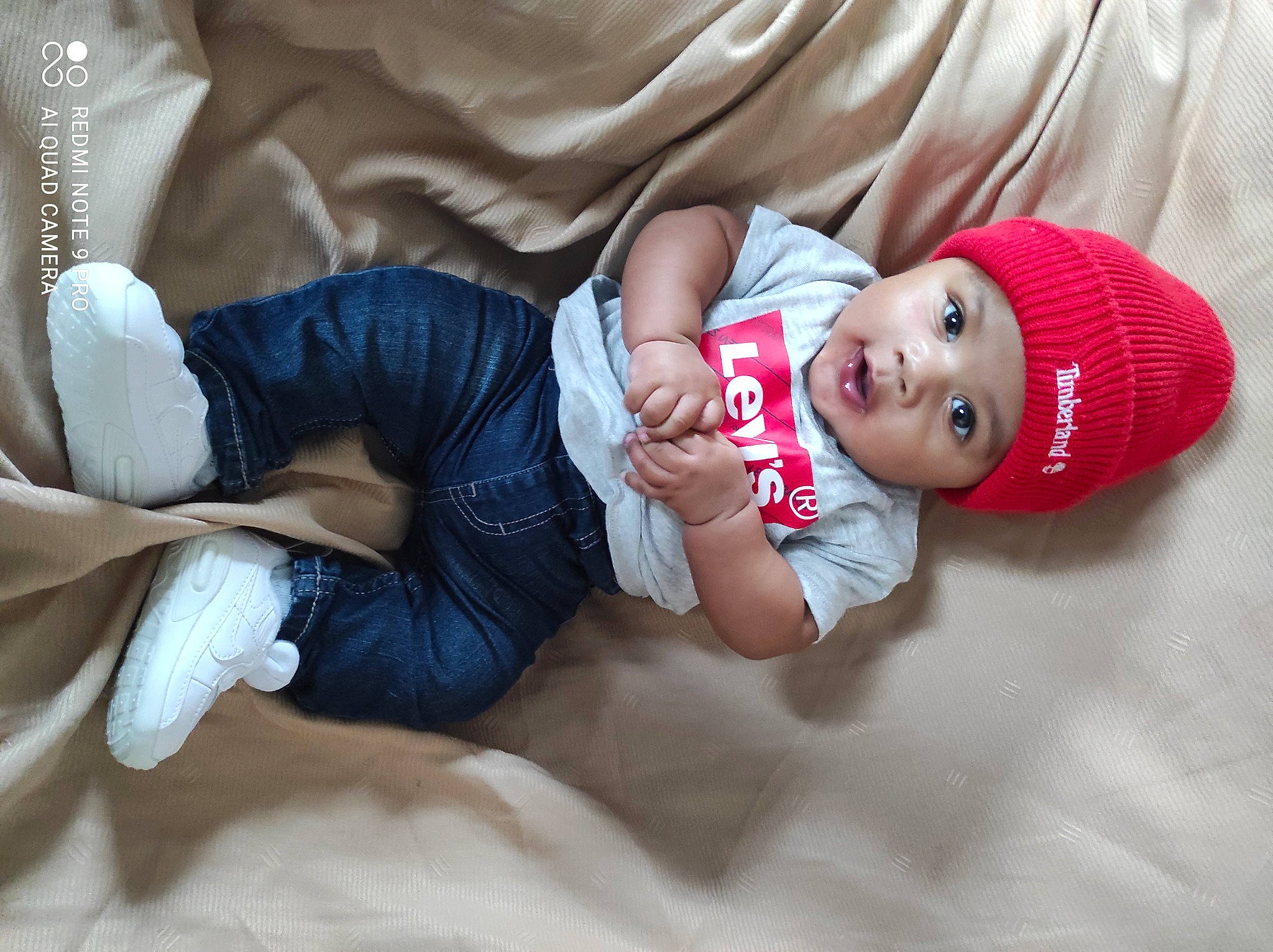 Kylian participe au concours pour gagner de l'argent avec cette photo : arm, baby, baby_sleeping, baby_toddler_clothing, comfort, eye, finger, hand, happy, hat, head, headwear, human_body, lap, leg, person, skin, sleeve, smile, sock