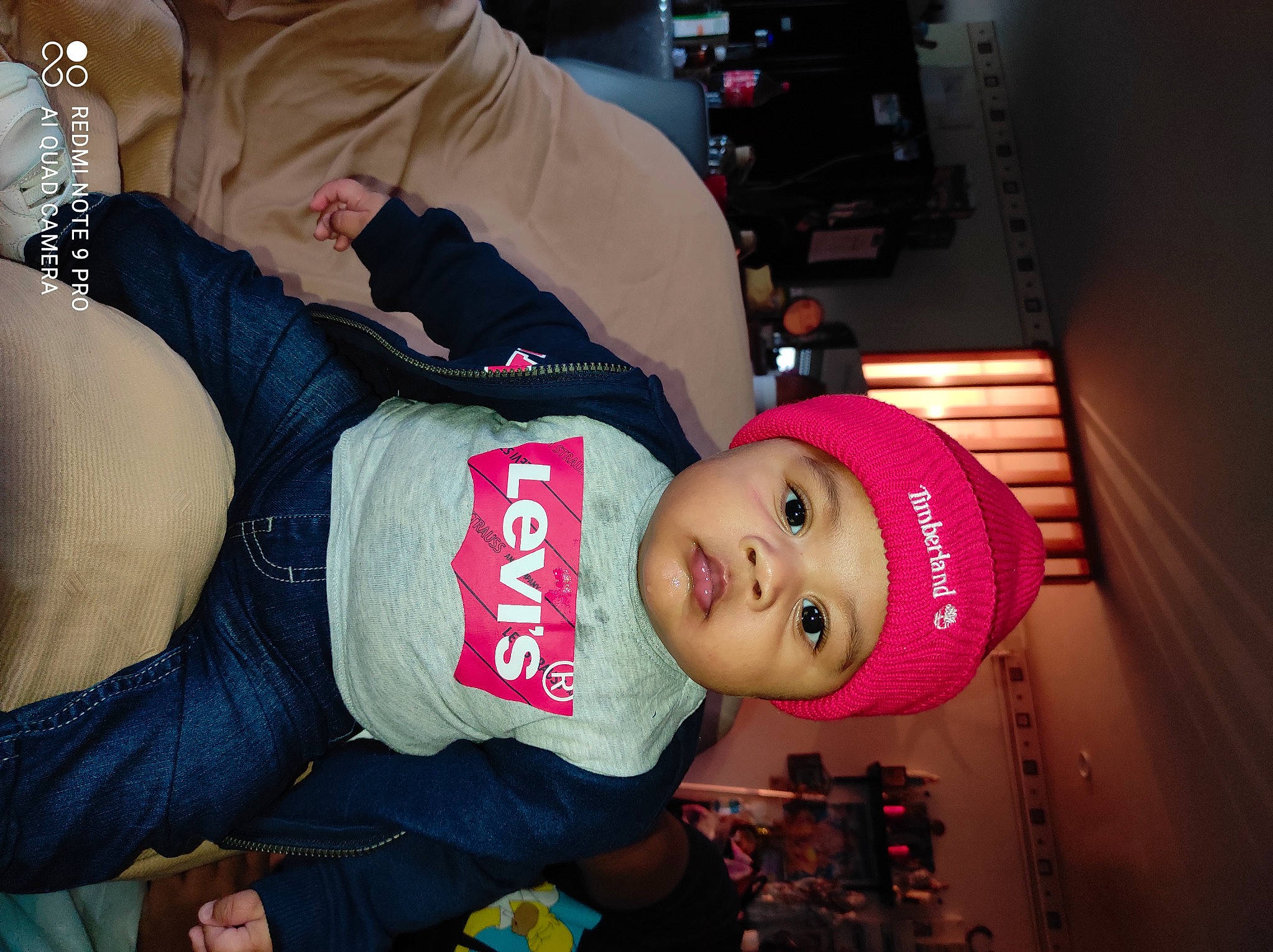 Kylian participe au concours pour gagner de l'argent avec cette photo : abdomen, baby, baby_toddler_clothing, beanie, cap, carmine, child, costume_hat, elbow, event, fashion_accessory, fun, hat, headwear, lap, magenta, person, room, sitting, smile