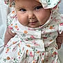 baby, child, infant, portrait, smile, face, hat, floral_dress, clothing, cute, cheeks, skin, eyes, person, sitting, indoors, soft_light, expression, closeup, adorable