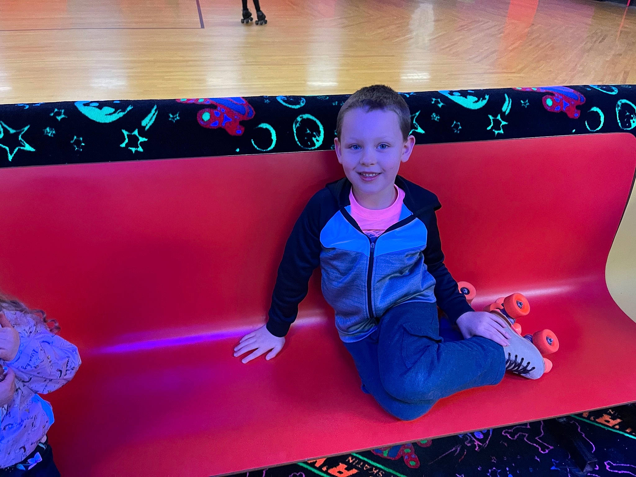 Hayden is registered to the contest to win money with this photo: child, electric_blue, entertainment, event, flooring, fun, human, joy, leisure, light, magenta, neon, performance, person, purple, recreation, red, room, sitting, smile