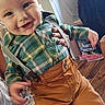 Richard is registered to the contest to win money with this photo: baby, child, smile, plaid_shirt, suspenders, brown_pants, person, hand, nail_polish, indoor, flooring, shoes, bag, holiday, christmas, wood_floor, happy, cute, portrait, clothing