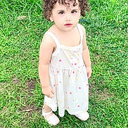 Ayzal is registered to the contest to win money with this photo: toddler, child, curly_hair, white_dress, white_shoes, grass, outdoor, greenery, cute, portrait, young_child, standing, nature, daylight, curious, innocent, person, small_child, summer, playful